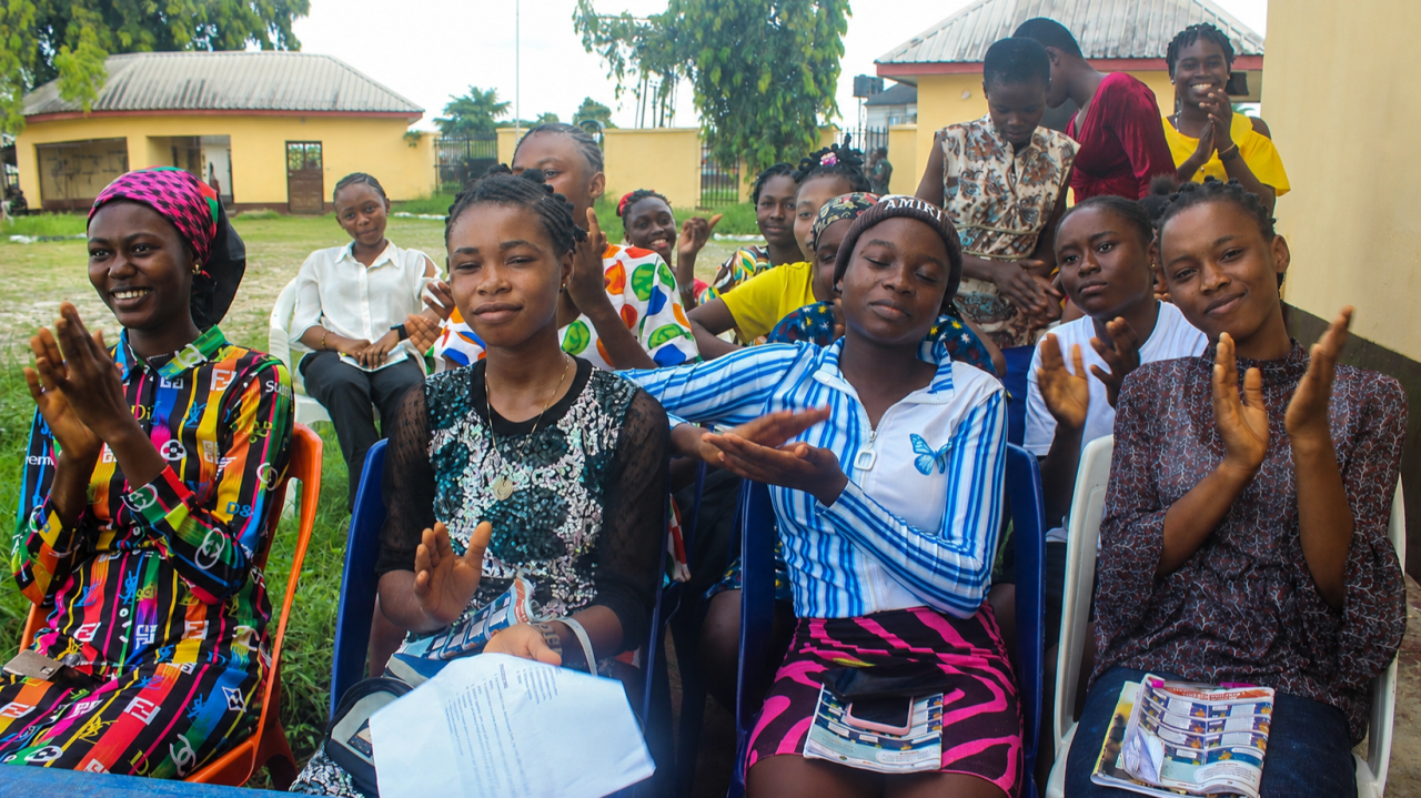 Adolescent girls clapping and smiling at an A360-HEEP safe-space session in Rivers State